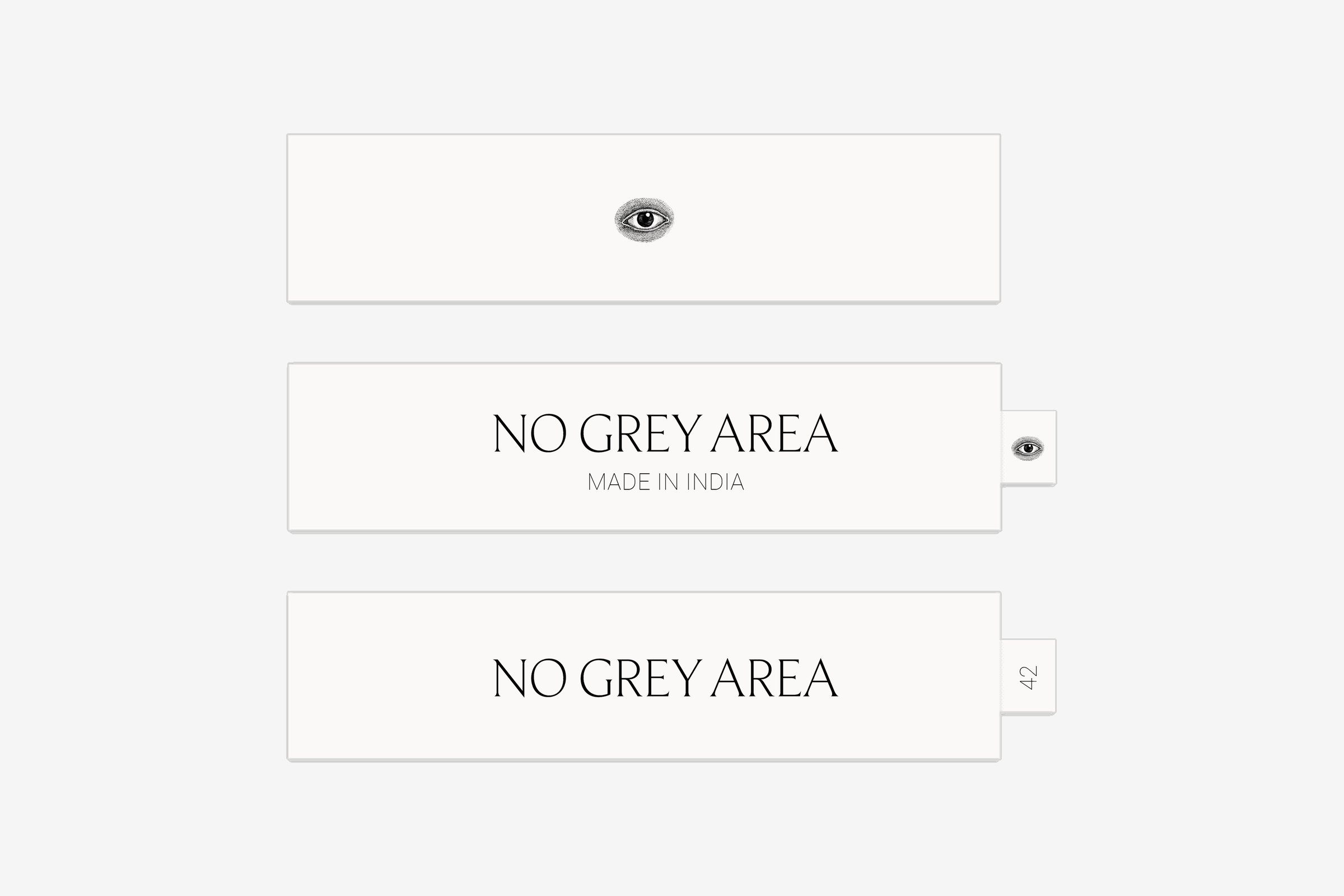 Three woven labels: one with the eye, two with the wordmark, one of them with an eye tab and one with a size tab